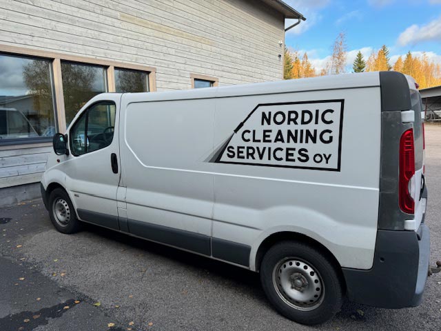 Teollisuuden kunnossapidon pakettiauto tiilirakennuksen edessä.